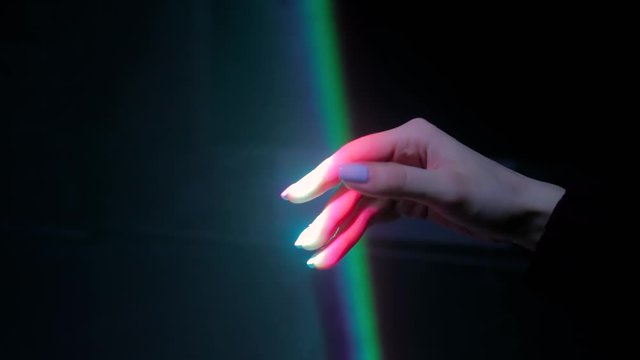 Interactive Exposition In Science Museum Or Exhibition: Bright Laser Light Installation. Woman Moving Hand Under Colorful Illumination - Close Up View. Optical And Visuals Concept