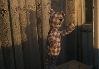 Covid19 pandemic. Going on a bear hunt concept. Toy cuddly bear stand on..windowsill. Photographed from outside on street.