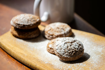 oatmeal cookies on a wooden board sprinkled with powdered sugar