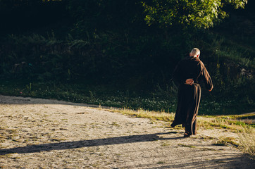 Fototapeta na wymiar a Catholic monk in robes praying in the woods. Copy space
