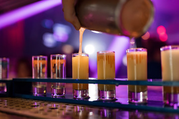 Bright cocktails - shots in the bar. Colorful footage in a nightclub. Alcoholic drink of different...