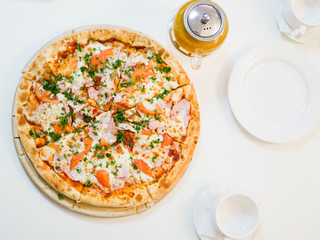 large view of pizza with bacon tomatoes and herbs.