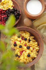 Breakfast with cereals, berries and milk in a rustic style
