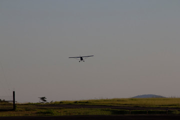 Fototapeta na wymiar Small airplane landing in the afternoon