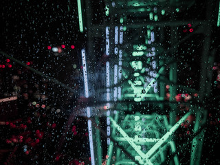 Night Rain Drops on a Glass with Neon Light lit Background