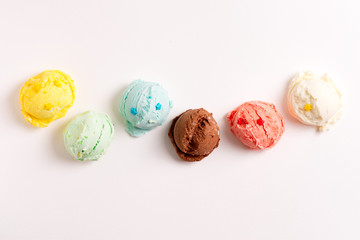 Colorful balls from freshly cooked homemade sweet ice-cream or gelato on a light grey background.