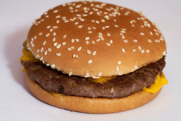 Fresh burger with beef, cheese and sesame seeds on a white background.