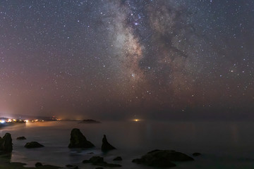 Milky Way Galaxy shining above Bandon Beach as fog comes ashore in Oregon
