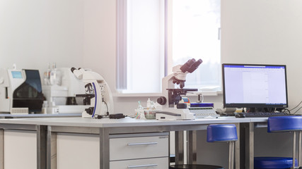 laboratory with modern equipment for blood analysis. The doctor checks the blood of patients. Microscope on the table. Blood test at a modern scientific workplace.