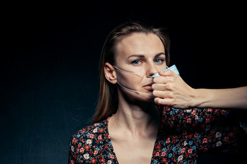 tired young woman wearing a medical mask tears it off her face