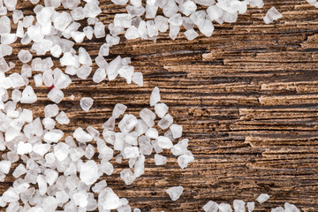 White sea crystal salt on the dark wooden background horizontal