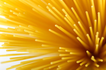 Long yellow spaghetti pasta food ingredient. Uncooked dry macaroni. Thin raw noodle. Cereal wheat product for delicious gourmet cooking. A useful source of carbohydrates. Healthy italian pasta.