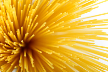 Long yellow spaghetti pasta food ingredient. Uncooked dry macaroni. Thin raw noodle. Cereal wheat product for delicious gourmet cooking. A useful source of carbohydrates. Healthy italian pasta.