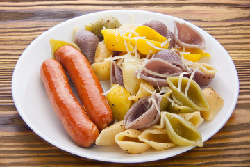 tasty appetizing pasta with German sausages on white plate