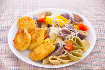 tasty appetizing pasta with chicken nuggets on white plate