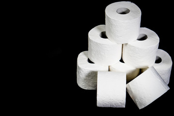 Composition with pile of white toilet papers on the black background. The topic is about Corona virus - COVID 19.