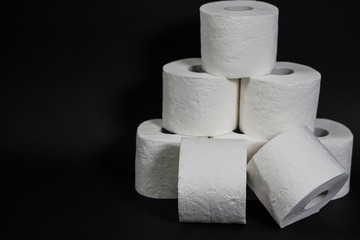 Composition with pile of white toilet papers on the black background. The topic is about Corona virus - COVID 19.