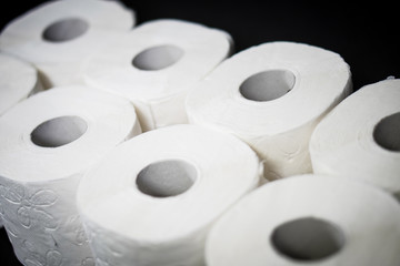 Composition with pile of white toilet papers on the black background. The topic is about Corona virus - COVID 19.