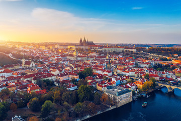 Obraz premium Aerial Prague panoramic drone view of the city of Prague at the Old Town Square, Czechia. Prague Old Town pier architecture and Charles Bridge over Vltava river in Prague at sunset, Czech Republic.