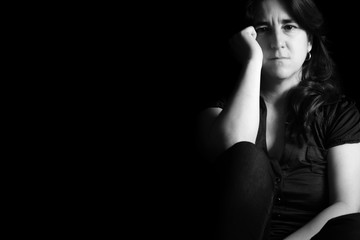 Sad woman isolated on a black background - Black and white portrait