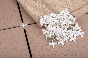 White plastic crosses used for tiling. The process of laying glaze in industry.