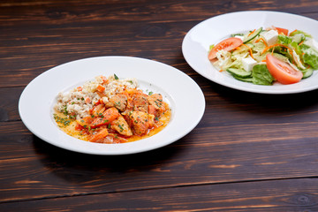 meat with barley and salad on the wooden background