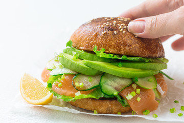 Beautiful, juicy burger with salted fish and avocado. Healthy eating. Source of Omega 3
