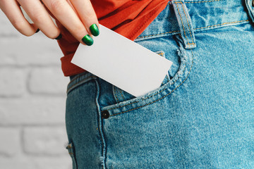 Girl's hand holding blank white business card close up