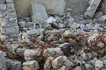 Destroyed brick walls of houses with rusty iron structural elements