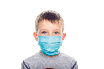 Little boy in a disposable mask on a light background. Kid is wearing the mask for protect them self from virus and air pollution