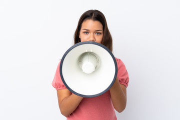 Young Colombian girl over isolated white background shouting through a megaphone