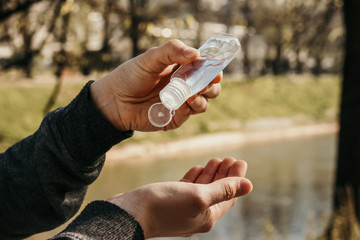 Person is using hand sanitizer (disinfecting gel) to wash hands while outdoor. High hygiene. Corona concept. Spring and summer during global pandemic crisis. COVID-19 virus. Coronavirus.Handshaking.
