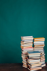many stacks of educational books in the university library on a green background