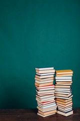 many stacks of educational books in the university library on a green background