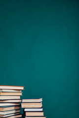 many stacks of educational books in the university library on a green background