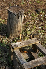 An old broken wooden chair lies on the grass in an abandoned garden