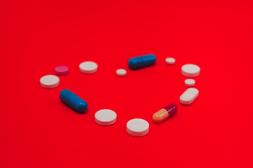 Heart Made From Capsules Over Blue Background