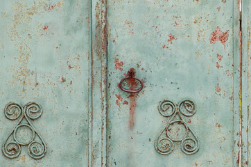 Old iron fence. Old cracked paint. Vintage fence. Rusty metal. Rust structure. Old vintage door handle. Padlock. Iron gate.