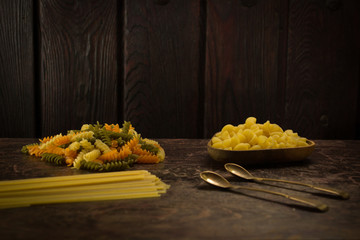 various types of pasta on a wooden background