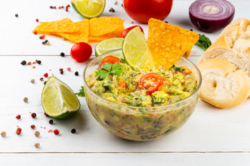 Delicious guacamole recipe and ingredients in the background. Diet vegetarian Mexican food avocado.