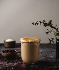 Dalgona coffee, trend korean drink, fluffy whipped coffee. Glass cup with a beverage, copy space.