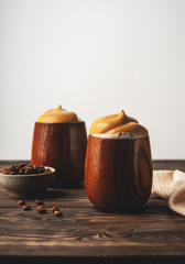 trend korean drink, fluffy whipped coffee, dalgona coffee,vintage wooden glasses with a beverage