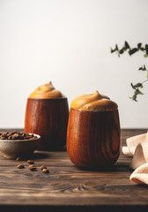 trend korean drink, fluffy whipped coffee, dalgona coffee,vintage wooden cups with a beverage