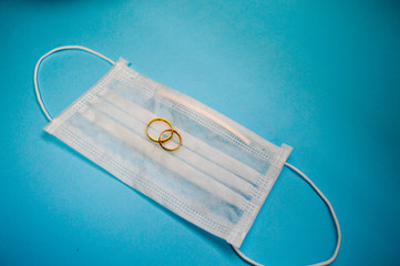 Gold wedding wedding rings lie on a disposable protective medical mask for protection against...