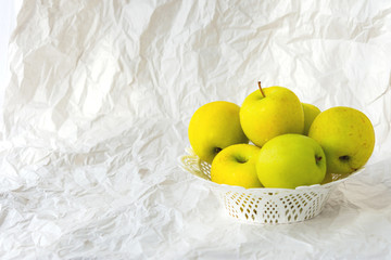 Yellow apples on a plate on a white paper background, still life with apples, Golden Apples