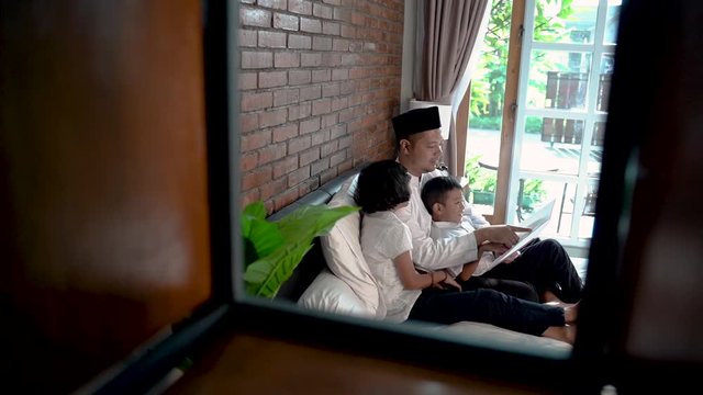 kids and father at home staying during ramadan reading a book