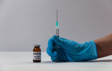 Coronavirus vaccine. Hands holding vaccine and syringe injection on white background. Prevention,...