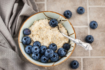 Close-up of oatmeal porridge with fresh blueberries for breakfast