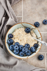 Close-up of oatmeal porridge with fresh blueberries for breakfast