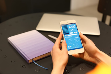 Woman using mobile phone for online banking at home